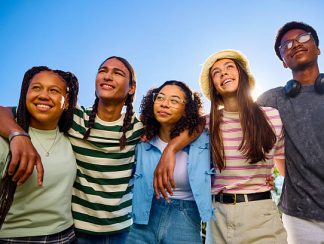 Group of teenager friends embracing and looking up at the sky